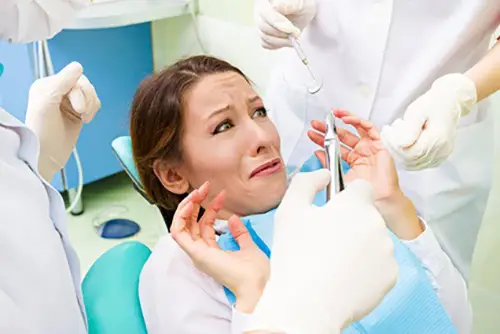 歯の治療が怖くて診療台で治療を拒む女性